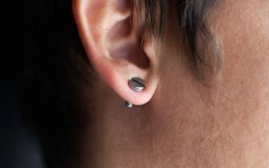 piercing in a man's ears closeup,ear tunnel.